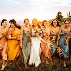 a group of women standing next to each other on top of a grass covered field