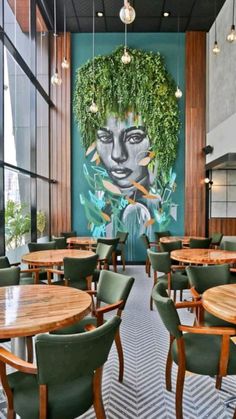 an empty restaurant with tables and green chairs