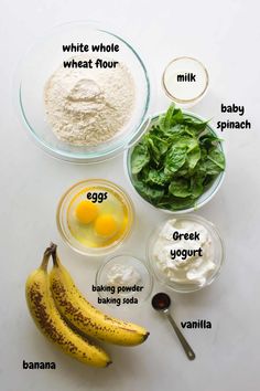 ingredients to make banana bread laid out on a white counter top, including eggs, milk, spinach and flour