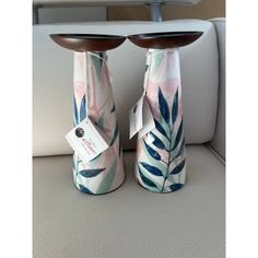 two vases sitting on the back of a car seat with tags attached to them