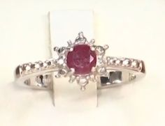 This is a beautiful genuine ruby and diamond ring. I think it would make a perfect promise ring, sweet sixteen, bat mitzvah, or if you are a July baby, this sweet ring could just be your special signature piece. Set with Sterling Silver and Platinum, this piece will never turn or tarnish. Currently a size 8.5. It is very easily sizable by any local jeweler. The center stone is slightly over 5 mm. The lovely full cut genuine diamond accents really makes this ring pop! It is simple, elegant, feminine and a classic. And now it's on Sale! Diamond Ruby Ring With Center Stone For Promise, Red Ring With Diamond Accents For Promise, Red Promise Ring With Diamond Accents, Red Rings With Diamond Accents For Promise, Ruby Rings With Diamond Accents For Gift, Red Birthstone Promise Ring With Diamond Accents, Ruby Birthstone Ring With Diamond Accents For Anniversary, Ruby Rings With Diamond Accents For Promise, Red Cluster Ring With Diamond Accents For Anniversary