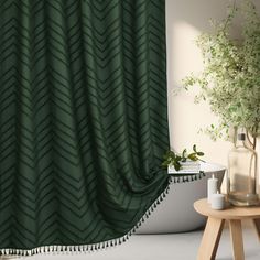 a green shower curtain in a bathroom next to a table with a potted plant