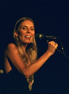 a woman standing in front of a microphone