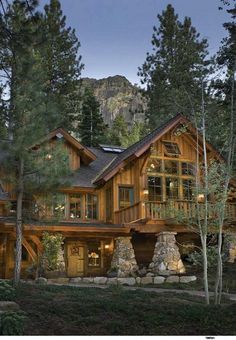 a large wooden house surrounded by trees and rocks