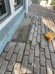 a brick sidewalk with a yellow block laying on it