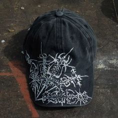 a black hat with white writing on the front and back side, sitting on concrete