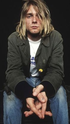 a man with long hair sitting on top of a chair