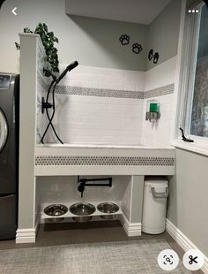 a washer and dryer in a small room with tile flooring on the walls