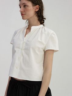 Editor's NoteThis is a button-up shirt with a Chinese collar design that stands out with a swollen shoulder line. The wide shirring along the neckline and the torsion lace detail that extends to the front placket add a light mood.- Add shoulder shirring to enhance the three-dimensional effect- Provides a cool fit in summer in the form of a spread collar- Bio-washed 20s medium-density 100% cotton fabric with natural cotton seeds and a soft texture.- Short length and cap sleeve design- 5 mother-of-pearl button fastening structure*Please refer to the detail cut for product color, and it may differ from the actual color depending on the monitor resolution.Measurements (in.)ONE SIZE (XS-M)- Shoulder: 14.96 in.- Chest: 20.67 in.- Armholes: 8.27 in.- Length: 18.9 in.*Model size: Height 5'71, Bust Relaxed Fit Puff Sleeve Tops With Buttons, Puff Sleeve Tops With Buttons In Relaxed Fit, Elegant Cotton Tops With Gathered Sleeves, Summer Button-up Tops With Gathered Sleeves, Relaxed Fit Tops With Gathered Sleeves And Button-up, Relaxed Fit Button-up Tops With Gathered Sleeves, Cotton Top With Ruffled Collar For Daywear, Spring Daywear Shirt With Gathered Sleeves, Spring Shirt With Gathered Sleeves For Daywear