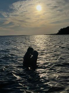 two people in the water kissing each other