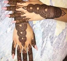 two hands with henna tattoos on them