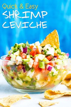 a bowl filled with guacamole and tortilla chips next to a blue background