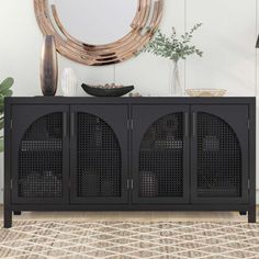 a black cabinet with three doors and a round mirror on the wall in front of it