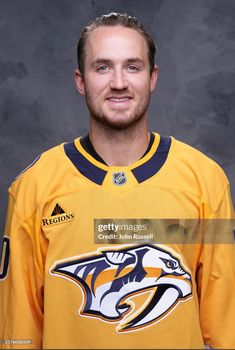 an ice hockey player poses for a photo in his uniform, wearing the nashville predators jersey