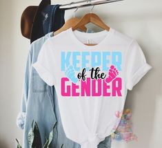 🎉 Keeper of the Gender Party T-Shirt 🎉 - Unisex Jersey Short Sleeve Tee! Rock this fun Gender Reveal Shirt and be the life of the party! Are you Team Blue 💙 or Team Pink 💖? Perfect for your pregnancy party shenanigans! Grab yours now and let the secret-keeping begin! 🤫👶 This classic unisex jersey short sleeve tee fits like a well-loved favorite. Soft cotton and quality print make users fall in love with it over and over again. These t-shirts have-ribbed knit collars to bolster shaping. The shoulders are tapered for a better fit over time. Dual side seams hold the garment's shape for longer.  .: Made with 100% Airlume combed and ring-spun cotton, a lightweight fabric (4.2 oz/yd² (142 g/m that is easy to layer, breathable. Perfect for active and leisure wear.  .: The retail fit that is Trendy Short Sleeve Tops For Gender Reveal, Blue Tops For Summer Gender Reveal, Trendy Crew Neck Tops For Gender Reveal, Trendy Graphic Print Tops For Gender Reveal, Gender Reveal Shirt Ideas, Keeper Of Gender Shirt, Trendy Crew Neck T-shirt For Gender Reveal, Cute Funny Print T-shirt For Gender Reveal, Cute T-shirt With Funny Print For Gender Reveal