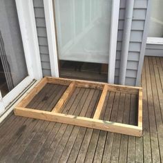 a wooden platform sitting on top of a wooden floor next to a door and window