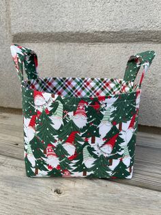 a green and red plaid bag with santa clause on it sitting on a wooden floor