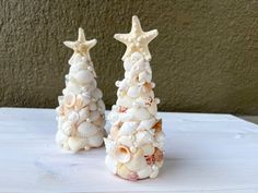 two small christmas trees made out of seashells