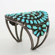 1940s Zuni Sterling Silver Cuff Bracelet set with Clusters of Natural American Turquoise. This bracelet is incredibly special as it is signed by the Zuni silversmith, Dena Bewanika, which is very rare for pieces from this time period.Dena Bewanika was featured in John Adair’s 1946 book, Navajo and Pueblo Silversmiths, where he attempted to list all the Zuni silversmiths producing jewelry in the early 1940s. Dena, born in 1910, was interviewed by Adair in the 1940s. He described her as an, “independent woman, living on her own very young as a cook at the Indian School. Old style work - easily confused with Navajo. Married to Harold Tucson, Jack Bobelu and Sol Yuselew.” Such biographical details are rarely available for early Zuni artists and incredible to find. We are pleased to include two Antique Turquoise Bangle, Antique Turquoise Bangle Cuff Bracelet, Vintage Turquoise Oyster Bracelet, Vintage Turquoise Round Cuff Bracelet, Independent Woman, Zuni Jewelry, Concho Belt, Navajo Jewelry, American Turquoise