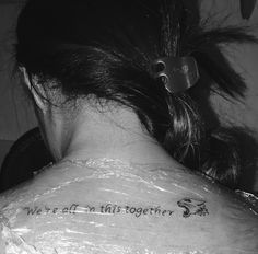 the back of a woman's neck with writing on it that says we are all this together