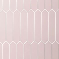 a white tiled wall with hexagonal tiles on the top and bottom half, in shades of pink