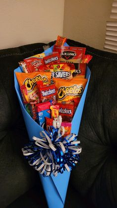 a blue paper bag filled with candy and candies on top of a black couch