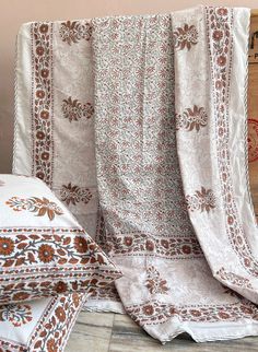 two beds covered with blankets and pillows on top of a wooden floor