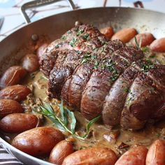 some meat and potatoes in a pan on a table