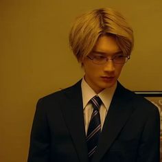 a young man wearing glasses and a suit