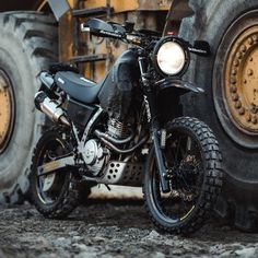 a motorcycle parked next to two large tires