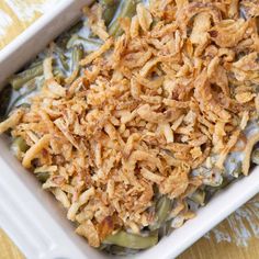 a casserole dish filled with green beans and shredded cheese