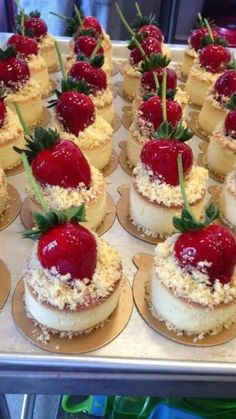 many small cakes with strawberries on them