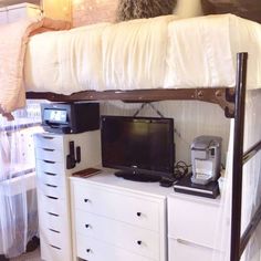 there is a tv on top of the dresser under the bunk bed with drawers underneath