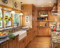 a kitchen filled with lots of wooden cabinets and counter top space next to a sink