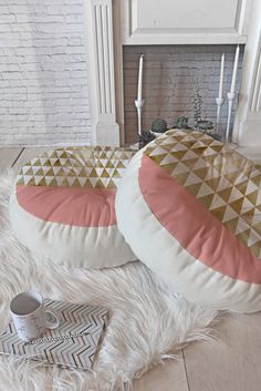 two round pillows sitting on top of a white rug