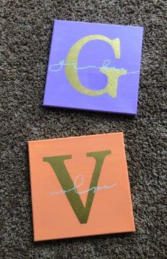 two small canvases with the letter g and v painted on them, sitting on carpet