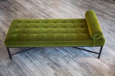 a green bench sitting on top of a hard wood floor