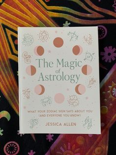 the magic of astrology book sitting on top of a blanket