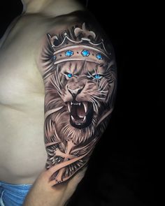 a man with a tattoo on his arm has a lion wearing a crown and blue eyes