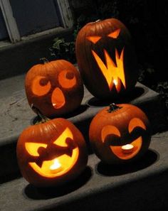 four carved pumpkins with faces on them sitting on the steps in front of a house