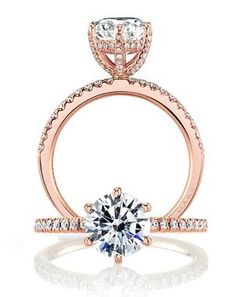 a rose gold engagement ring with an oval cut diamond on the band and side stones