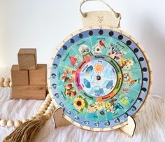 a wooden wheel with animals on it next to some beads and wood blocks in the background