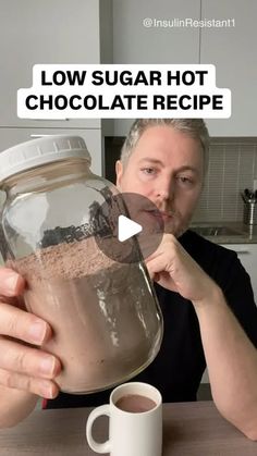 a man holding a jar filled with hot chocolate in front of a cup and saucer