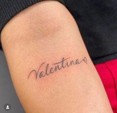 a woman's arm with the word valentine tattooed on her left side, in cursive font