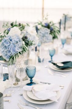 the table is set with blue and white flowers