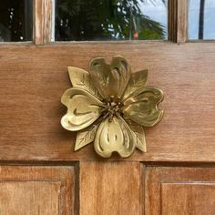 a close up of a wooden door with a metal flower on the front and side