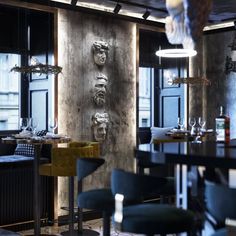 the dining room is set up with black chairs and marble wall sculptures on the walls