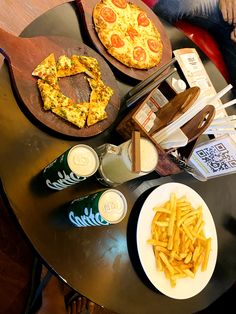 two pizzas and french fries on a table