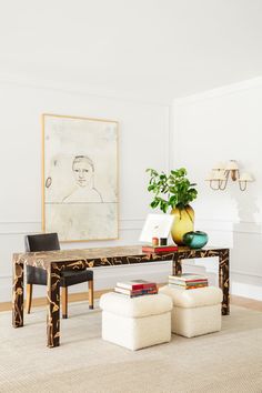 a living room filled with furniture and a large painting on the wall above it's coffee table