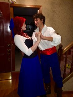 the man and woman are dressed up as disney characters, one is wearing a red - haired